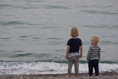 两个孩子站在岸上